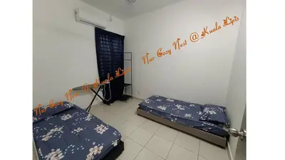 a bedroom with two beds in a room with a window at Nur Cozy Nest Homestay in Kuala Lipis