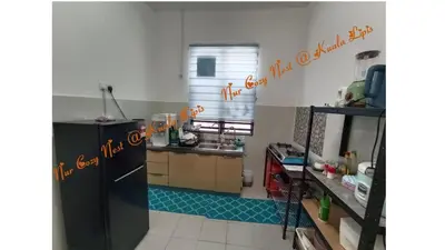 a kitchen with a refrigerator and a sink at Nur Cozy Nest Homestay in Kuala Lipis