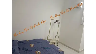 a bedroom with a bed and a sign on the wall at Nur Cozy Nest Homestay in Kuala Lipis