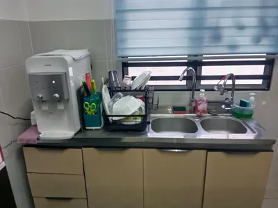 a kitchen counter with a sink and a coffee maker at Nur Cozy Nest Homestay in Kuala Lipis