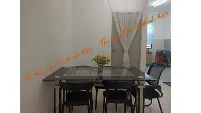 a dining room with a glass table and chairs at Nur Cozy Nest Homestay in Kuala Lipis