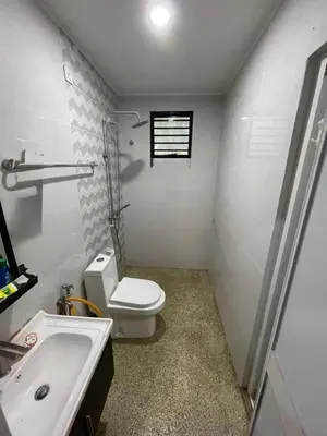 a white bathroom with a toilet and a sink at Laman Serambi Homestay in Hutan Melintang