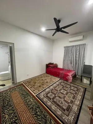 a bedroom with two rugs on the floor and a ceiling fan at Laman Serambi Homestay in Hutan Melintang