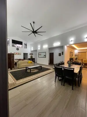 a living room with a table and a couch at Laman Serambi Homestay in Hutan Melintang