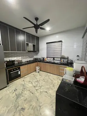 a large kitchen with a ceiling fan in it at Laman Serambi Homestay in Hutan Melintang
