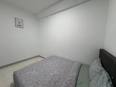 a bedroom with a bed in a white room at Penang Miami Beach in Batu Ferringhi