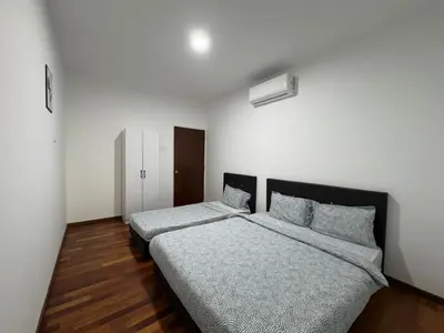 two beds in a room with white walls and wooden floors at Penang Miami Beach in Batu Ferringhi