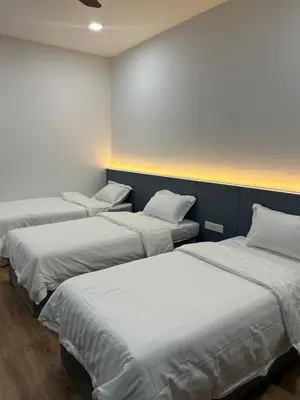 a row of beds in a room with white sheets at Cozy Nook Stay Bukit Tinggi 2 in Kuang