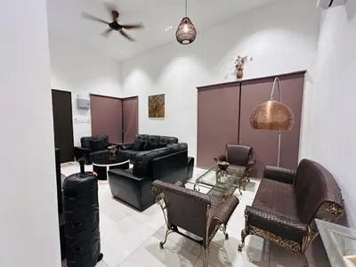 a living room with black furniture and a ceiling fan at Ethereal Ipoh Homestay in Ipoh