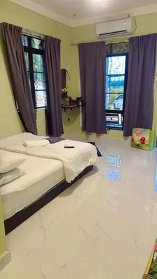 a bedroom with a bed and two windows at TGB Buhayra CHALLET & CAMPSITE