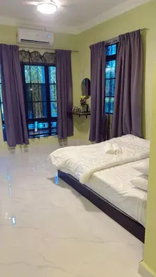 a large bed in a room with purple windows at TGB Buhayra CHALLET & CAMPSITE