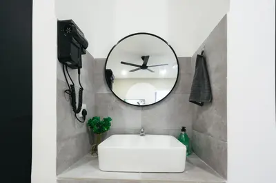 a bathroom with a white tub and a round mirror at Cameron Centrum CozyNest with Kids Playground Brinchang Clover Home A-1-15A in Brinchang