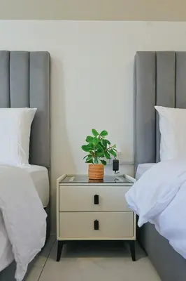 a nightstand with a plant on it next to two beds at Cameron Centrum CozyNest with Kids Playground Brinchang Clover Home A-1-15A in Brinchang