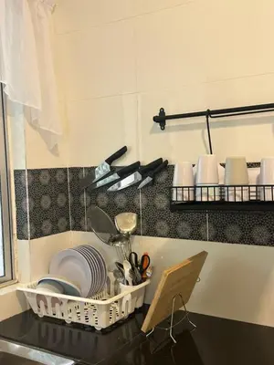 a kitchen counter with plates and utensils on a shelf at Adik Aisyah homestay quintet 7-2 in Tanah Rata