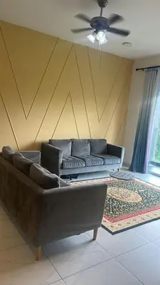 a living room with a couch and a ceiling fan at Adik Aisyah homestay cameron quintet A3-7-3 in Tanah Rata