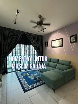 a living room with a green couch and a large window at Adik Aisyah homestay cameron quintet A3-7-3A in Tanah Rata