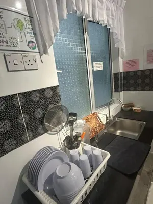 a kitchen with a sink and a tray of dishes at Adik Aisyah homestay cameron quintet A3-7-3A in Tanah Rata