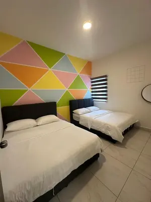 two beds in a room with a colorful wall at Adik Aisyah cameron homestay quintet A3-7-7 in Tanah Rata