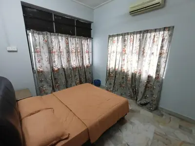 a bedroom with a bed and two windows with curtains at 50 Canning Garden Homestay in Ipoh