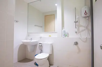 a bathroom with a toilet and a sink and a mirror at Spacious 4BR Double Storey Home Balik Pulau in Balik Pulau