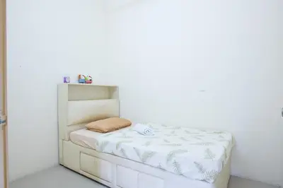a small bed in a room with a white wall at Spacious 4BR Double Storey Home Balik Pulau in Balik Pulau
