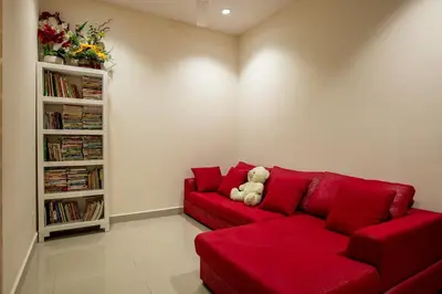 a red couch in a living room with a teddy bear at Spacious 4BR Double Storey Home Balik Pulau in Balik Pulau