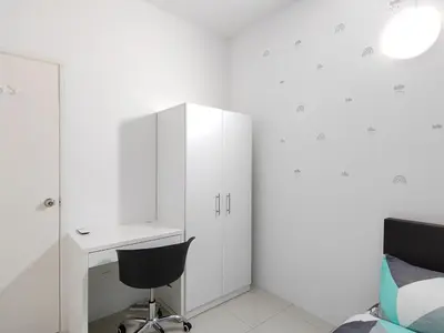 a white bedroom with a desk and a chair at Ipoh Anderson Suites in Ipoh