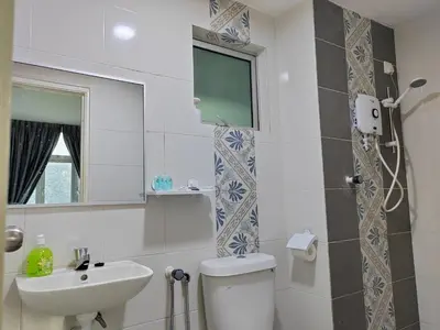 a bathroom with a toilet and a sink and a mirror at Ipoh Anderson Suites in Ipoh