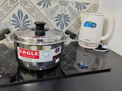a coffee pot sitting on a counter next to a cup at Ipoh Anderson Suites in Ipoh