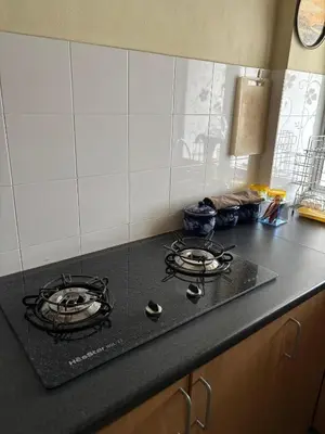 a kitchen counter with two burners on a stove top at ANHAAZ Lakefront Retreat in Kampong Balek Bukit