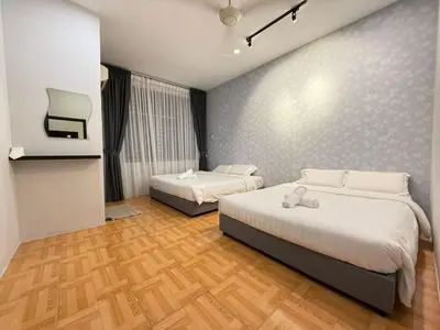 a bedroom with two beds and a tv in it at Relax Guest House Taman Merak Jaya Simpang Ampat in Simpang Ampat