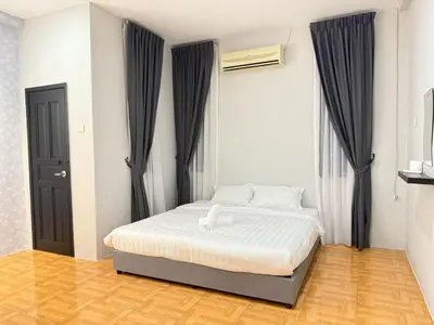 a bedroom with a bed with black curtains at Relax Guest House Taman Merak Jaya Simpang Ampat in Simpang Ampat