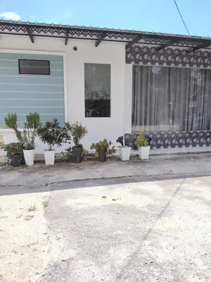 a house with potted plants in front of it at Makwan Homestay B in Kubang Semang