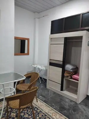 a room with a table and chairs and a bed at Makwan Homestay B in Kubang Semang