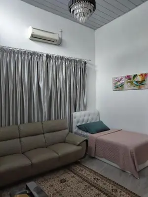 a living room with a couch and a bed at Makwan Homestay B in Kubang Semang