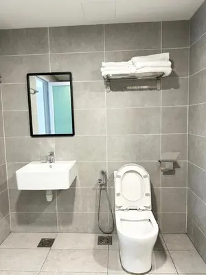 a bathroom with a toilet and a sink and a mirror at ICC Suites Ipoh 16th floor in Ipoh