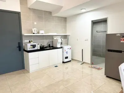a kitchen with white cabinets and a refrigerator at ICC Suites Ipoh 16th floor in Ipoh