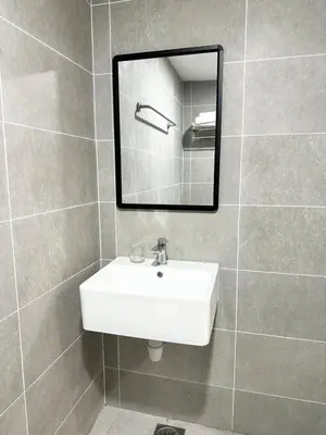 a bathroom with a white sink and a mirror at ICC Suites Ipoh 16th floor in Ipoh