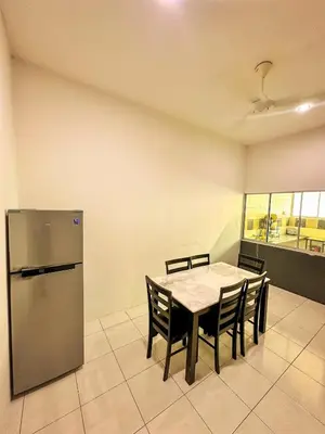 a kitchen with a table with chairs and a refrigerator at Sofea Homestay Raban Lake in Kampong Kuala Chegar