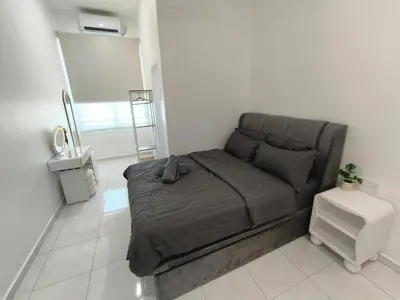 a bedroom with a bed with a gray blanket at Spacious, 2 Storey Home, Up to 12 Pax, 4 Bedrooms, 4 Bathrooms, 2 Car Park Lots by Star Home in Sungai Petani
