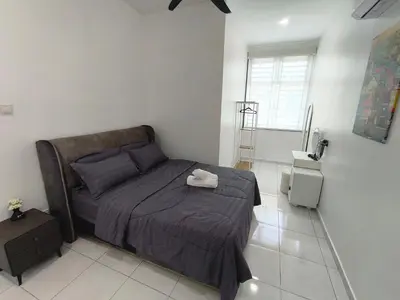 a bedroom with a bed with a purple comforter at Spacious, 2 Storey Home, Up to 12 Pax, 4 Bedrooms, 4 Bathrooms, 2 Car Park Lots by Star Home in Sungai Petani
