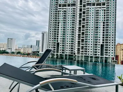 a pool with chairs and a table in front of a building at Cozy Sea & City View Penang, 3BR-10PAX b30 in George Town