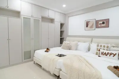 a white bedroom with a large bed with a happy pillow at Bm16 16pax4b3b in Bukit Mertajam