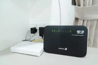 a router sitting on a table next to a laptop at Bm16 16pax4b3b in Bukit Mertajam