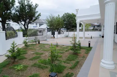 a courtyard with a white fence and trees at Bm16 16pax4b3b in Bukit Mertajam