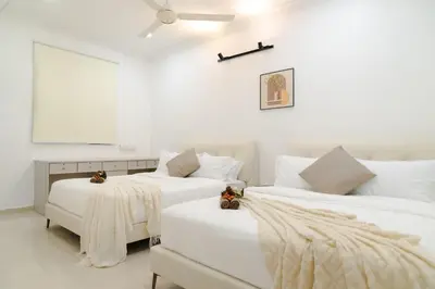 two beds in a room with white walls at Bm16 16pax4b3b in Bukit Mertajam