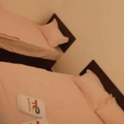 a bed with black and white pillows on it at mulia homestay in Teluk Intan