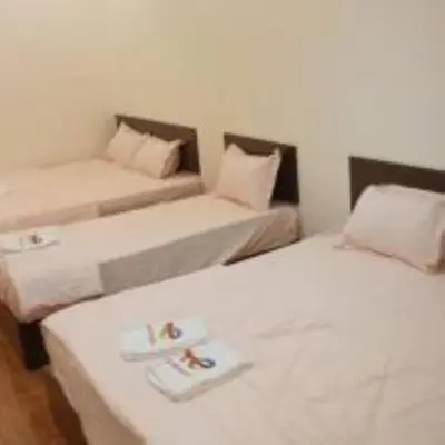a room with two beds and a couch at mulia homestay in Teluk Intan