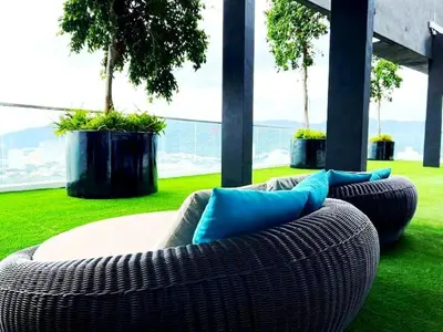 a couch with blue pillows sitting on the grass at relax familystay Urban suites 3BR-10pax b30 in George Town