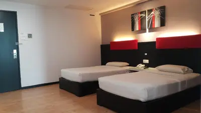 a room with two beds and a phone in it at Red Rock Hotel Penang in George Town